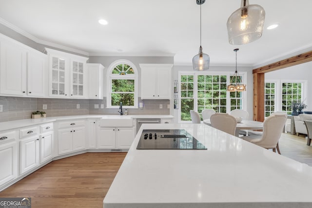 100 Castlebrook Chase, Tyrone, GA 30290 - kitchen featuring black electric cooktop, a kitchen island, ornamental molding, a chandelier, and tasteful backsplash