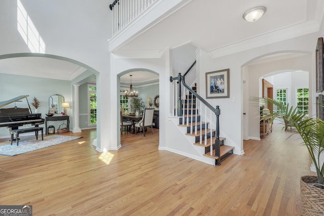 100 Castlebrook Chase, Tyrone, GA 30290 - entrance foyer with light wood-style floors, stairs, crown molding, and arched walkways