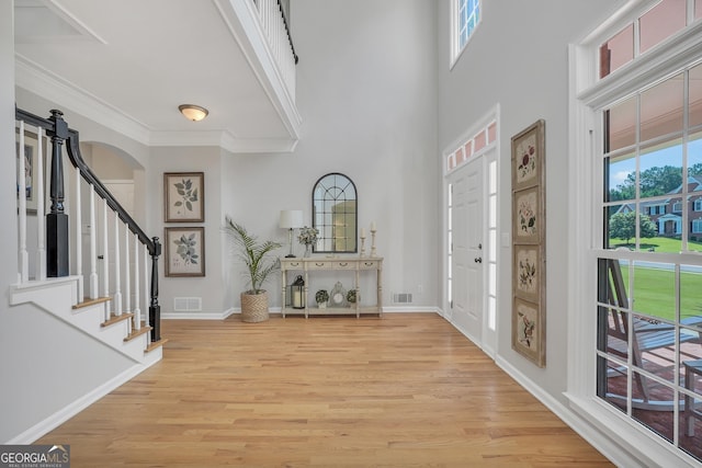 100 Castlebrook Chase, Tyrone, GA 30290 - entrance foyer featuring arched walkways, plenty of natural light, light wood-style flooring, stairway, and crown molding