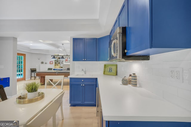 100 Castlebrook Chase, Tyrone, GA 30290 - kitchen featuring blue cabinets, stainless steel microwave, decorative backsplash, light countertops, and beam ceiling