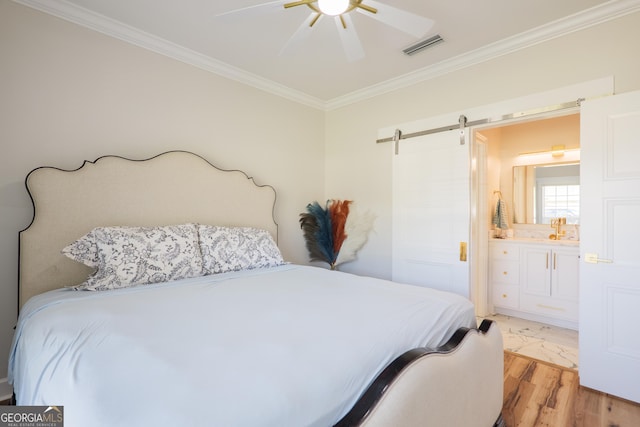 1112 Old Meadow Rd, Valdosta, GA 31605 - bedroom with crown molding, a barn door, light wood finished floors, ensuite bath, and ceiling fan