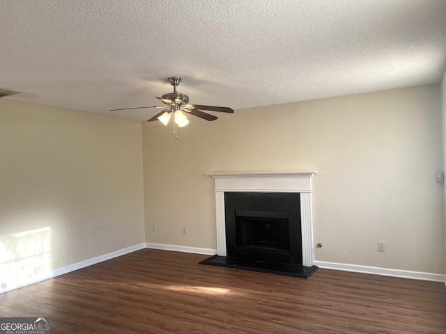 2561 Lancewood Ln, Lithonia, GA 30058 - unfurnished living room featuring dark wood-style flooring, a ceiling fan, a fireplace, and a textured ceiling