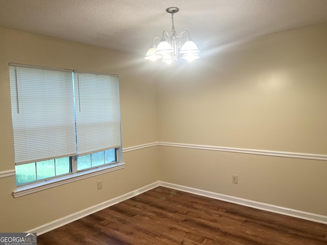 2561 Lancewood Ln, Lithonia, GA 30058 - empty room with a chandelier, dark wood-style flooring, and a textured ceiling
