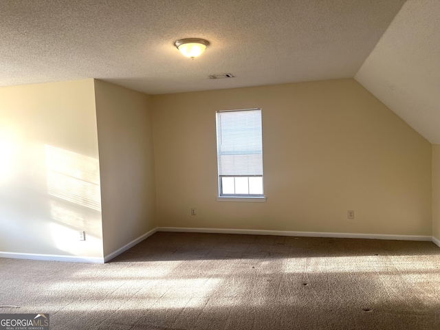 2561 Lancewood Ln, Lithonia, GA 30058 - bonus room featuring carpet flooring, vaulted ceiling, and a textured ceiling