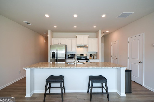 428 Whitetail Cir, Canton, GA 30115 - kitchen with appliances with stainless steel finishes, under cabinet range hood, an island with sink, dark wood-style flooring, and recessed lighting