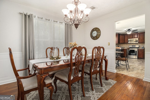 5086 N Woodbridge Trl, Stone Mountain, GA 30088 - dining room with a chandelier, light wood finished floors, a wainscoted wall, and a ceiling fan