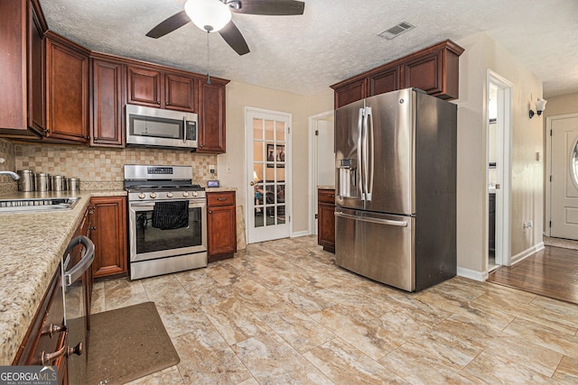 5086 N Woodbridge Trl, Stone Mountain, GA 30088 - kitchen featuring appliances with stainless steel finishes, backsplash, a ceiling fan, and a textured ceiling
