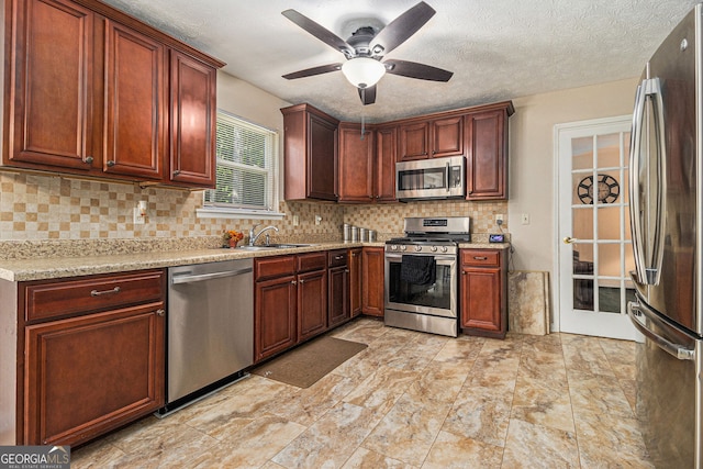 5086 N Woodbridge Trl, Stone Mountain, GA 30088 - kitchen with stainless steel appliances, a ceiling fan, decorative backsplash, light stone counters, and a textured ceiling
