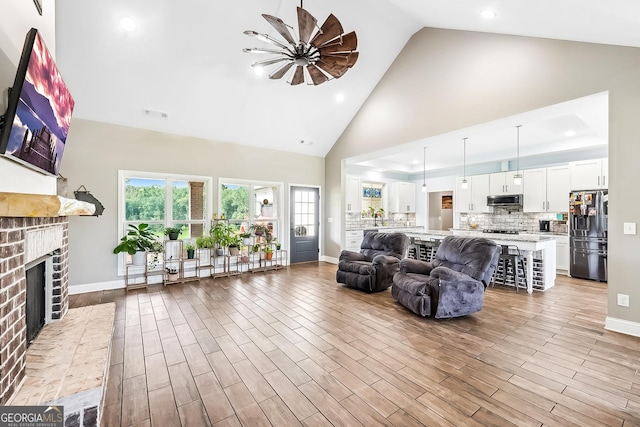 357 Old Driver Rd, Whitesburg, GA 30185 - living room with a brick fireplace, high vaulted ceiling, a ceiling fan, wood finished floors, and recessed lighting