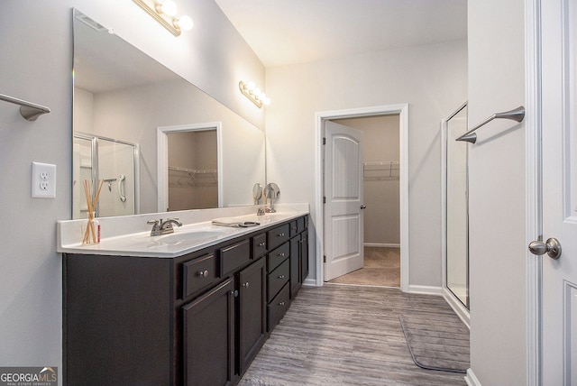 111 Point View Dr, Canton, GA 30114 - bathroom with a walk in closet, wood finished floors, double vanity, and a stall shower