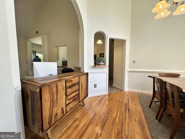 235 Pirkle Ct, Cumming, GA 30040 - interior space with light wood finished floors, high vaulted ceiling, arched walkways, and a chandelier