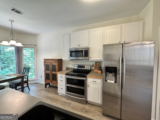 235 Pirkle Ct, Cumming, GA 30040 - kitchen featuring appliances with stainless steel finishes, white cabinets, light wood-style flooring, hanging light fixtures, and a chandelier