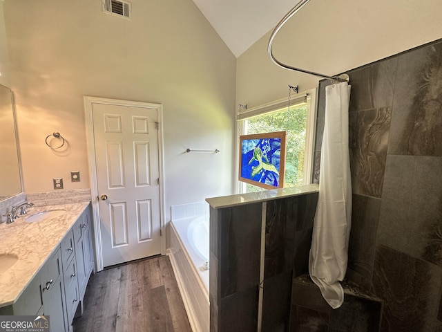 235 Pirkle Ct, Cumming, GA 30040 - full bathroom featuring a bath, wood finished floors, high vaulted ceiling, a tile shower, and double vanity