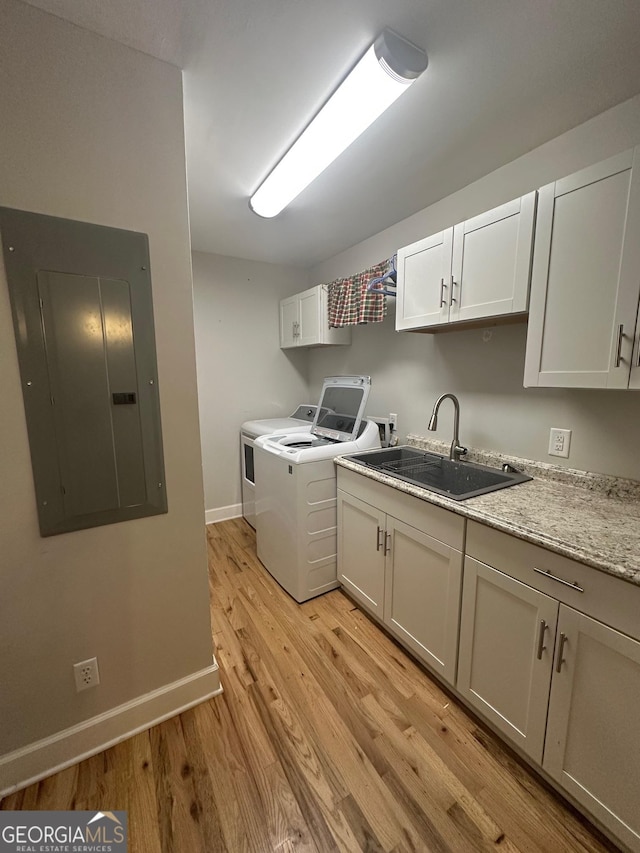 1408 Main St, Perry, GA 31069 - laundry area with electric panel, cabinet space, washing machine and dryer, and light wood-style flooring