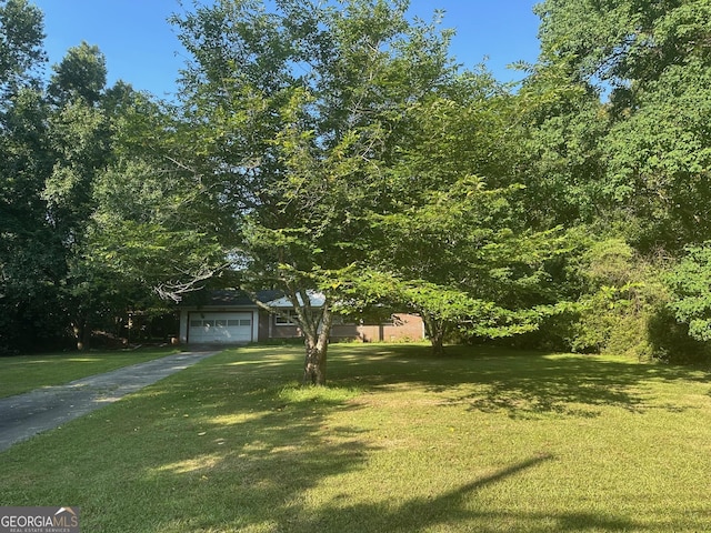 1408 Main St, Perry, GA 31069 - obstructed view of property featuring a garage, driveway, and a front yard