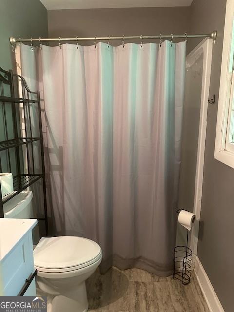 1408 Main St, Perry, GA 31069 - full bathroom with vanity, wood finished floors, and a shower with shower curtain
