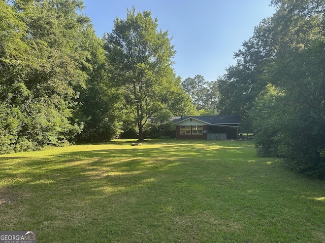 1408 Main St, Perry, GA 31069 - view of grassy yard featuring a carport