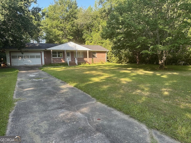 1408 Main St, Perry, GA 31069 - ranch-style house featuring asphalt driveway, a front yard, a garage, covered porch, and brick siding
