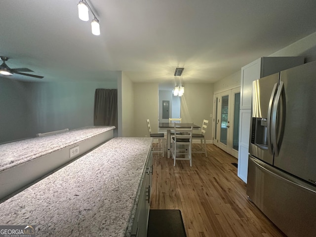 1408 Main St, Perry, GA 31069 - kitchen featuring stainless steel fridge, wood finished floors, electric panel, a ceiling fan, and pendant lighting
