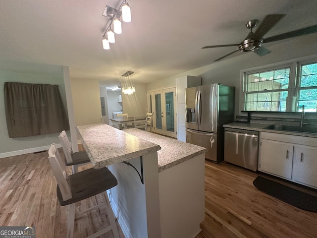 1408 Main St, Perry, GA 31069 - kitchen with stainless steel appliances, wood finished floors, ceiling fan, and white cabinets