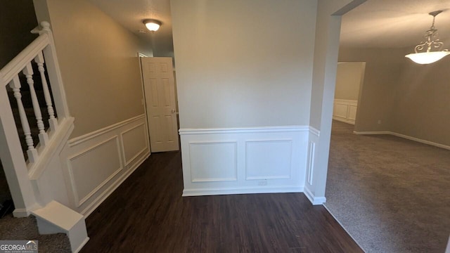 705 Mustang Ct, Hampton, GA 30228 - hallway featuring a decorative wall, wainscoting, stairs, and dark wood-type flooring