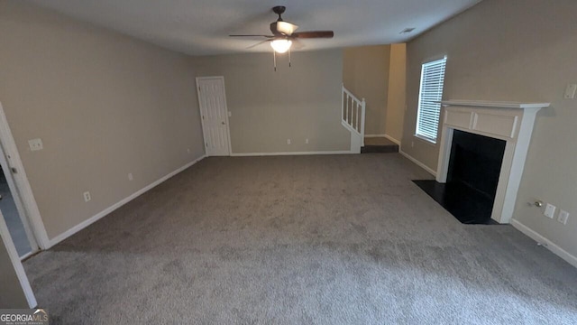 705 Mustang Ct, Hampton, GA 30228 - unfurnished living room with carpet flooring, ceiling fan, stairway, and a fireplace with flush hearth