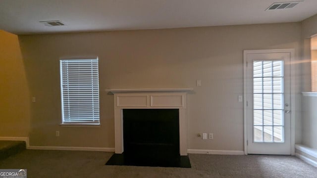 705 Mustang Ct, Hampton, GA 30228 - unfurnished living room with carpet floors, a fireplace with flush hearth, and plenty of natural light