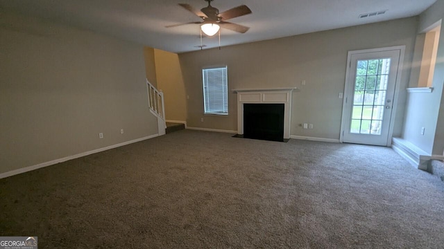 705 Mustang Ct, Hampton, GA 30228 - unfurnished living room with ceiling fan, stairway, carpet floors, and a fireplace with flush hearth