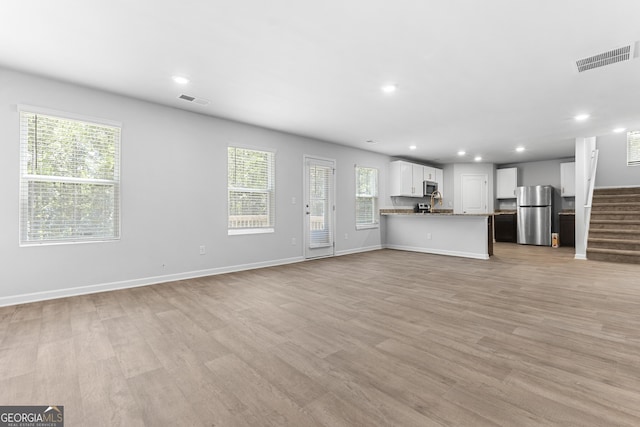 155 Shetland Pines Dr, Macon, GA 31216 - unfurnished living room featuring light wood finished floors, recessed lighting, stairs, and plenty of natural light