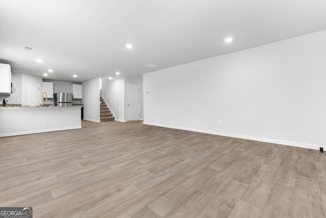 155 Shetland Pines Dr, Macon, GA 31216 - unfurnished living room featuring recessed lighting, stairway, and light wood-style flooring