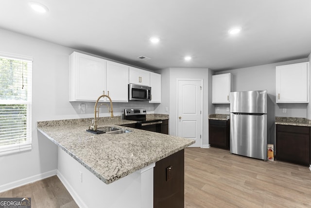 155 Shetland Pines Dr, Macon, GA 31216 - kitchen featuring appliances with stainless steel finishes, light stone countertops, light wood finished floors, recessed lighting, and white cabinetry