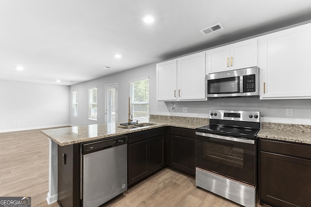155 Shetland Pines Dr, Macon, GA 31216 - kitchen featuring stainless steel appliances, light wood finished floors, a peninsula, recessed lighting, and white cabinets
