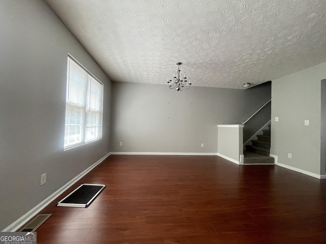 6361 Redan Sq, Lithonia, GA 30058 - unfurnished living room featuring a textured ceiling, a chandelier, stairs, and wood finished floors