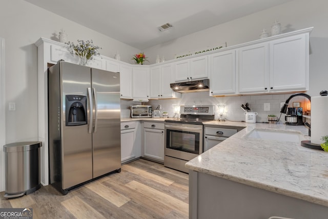 259 Coweta St, Senoia, GA 30276 - kitchen with appliances with stainless steel finishes, under cabinet range hood, light wood-type flooring, and backsplash