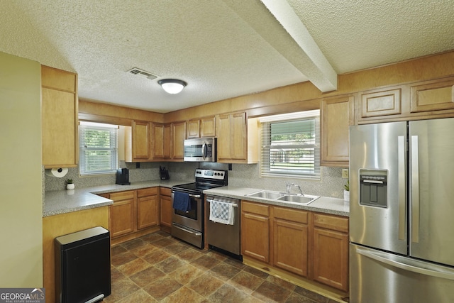 233 S Sheffield St, Kingsland, GA 31548 - kitchen with stainless steel appliances, a textured ceiling, backsplash, and light countertops
