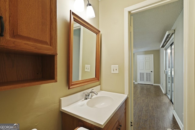233 S Sheffield St, Kingsland, GA 31548 - half bathroom with vanity, wood finished floors, and a textured ceiling