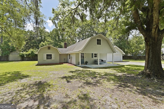 233 S Sheffield St, Kingsland, GA 31548 - view of front of home with a gambrel roof, driveway, a chimney, and view of scattered trees