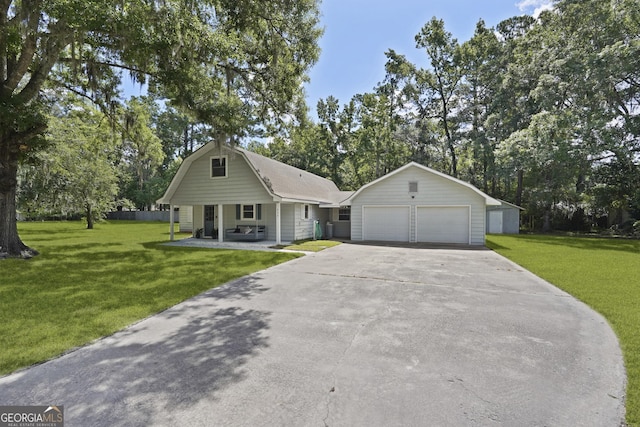 233 S Sheffield St, Kingsland, GA 31548 - view of front facade with a front yard, an outbuilding, a porch, and concrete driveway