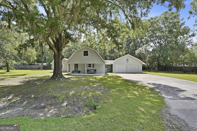 233 S Sheffield St, Kingsland, GA 31548 - view of front of house featuring concrete driveway, covered porch, a garage, view of wooded area, and a gambrel roof