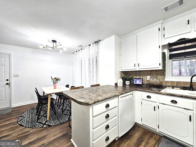 164 Turner Creek Dr, Hampton, GA 30228 - kitchen with dishwasher, dark countertops, a peninsula, dark wood-style flooring, and a chandelier