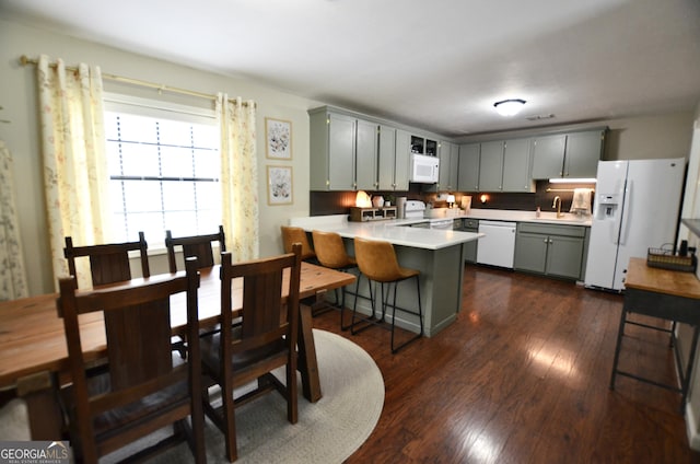 68 Archie Ln, Pine Mountain, GA 31822 - kitchen featuring white appliances, a peninsula, dark wood-style floors, and light countertops