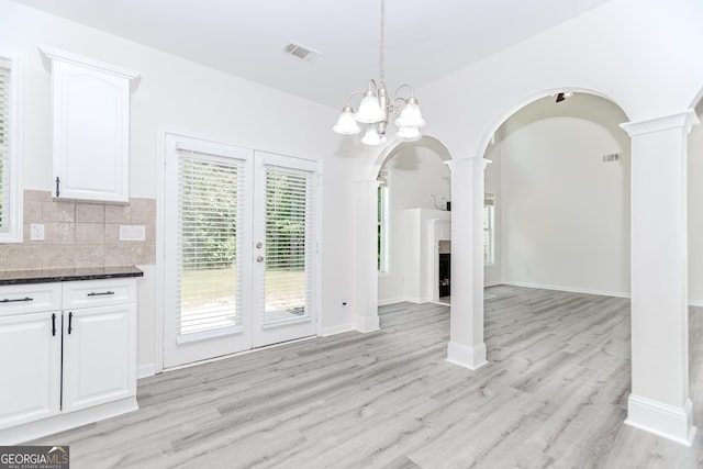 2023 Jameson Cir, Lawrenceville, GA 30043 - unfurnished dining area featuring ornate columns, light wood-style floors, and arched walkways