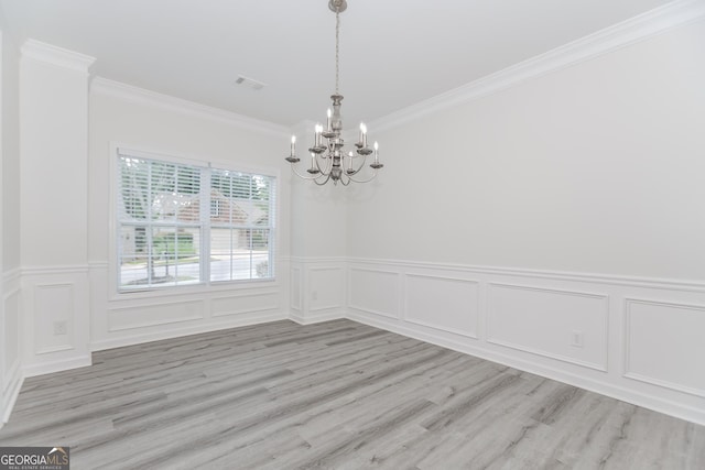 2023 Jameson Cir, Lawrenceville, GA 30043 - unfurnished dining area with a chandelier, ornamental molding, wainscoting, a decorative wall, and light wood-type flooring