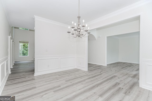 2023 Jameson Cir, Lawrenceville, GA 30043 - unfurnished dining area featuring a chandelier, light wood finished floors, crown molding, a decorative wall, and a wainscoted wall