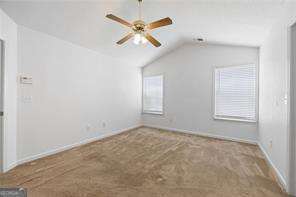 4527 Baker Grove Rd NW, Acworth, GA 30101 - empty room with vaulted ceiling, ceiling fan, and carpet floors