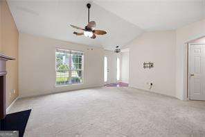 4527 Baker Grove Rd NW, Acworth, GA 30101 - unfurnished living room featuring lofted ceiling, carpet, and ceiling fan