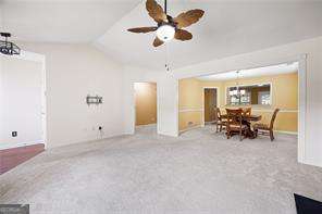 4527 Baker Grove Rd NW, Acworth, GA 30101 - living room featuring lofted ceiling, ceiling fan, carpet flooring, and a chandelier