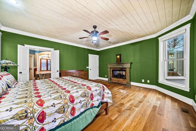 1043 Deer Run Rdg, Jasper, GA 30143 - bedroom with crown molding, wood ceiling, wood finished floors, a glass covered fireplace, and a ceiling fan