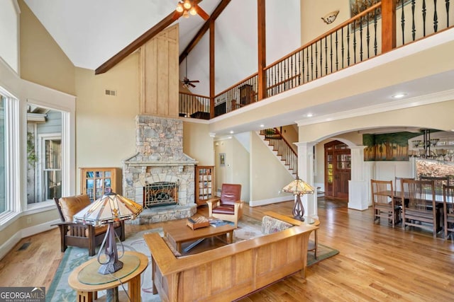1043 Deer Run Rdg, Jasper, GA 30143 - living room with high vaulted ceiling, ceiling fan, a fireplace, wood finished floors, and arched walkways