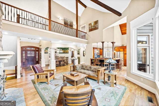 1043 Deer Run Rdg, Jasper, GA 30143 - living area featuring ornate columns, high vaulted ceiling, light wood-type flooring, beamed ceiling, and arched walkways